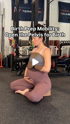 a pregnant woman sitting on the floor in a gym