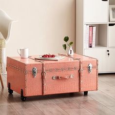 an orange suitcase sitting on top of a hard wood floor next to a white chair