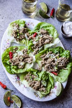 lettuce wraps filled with meat and garnishes on a white plate