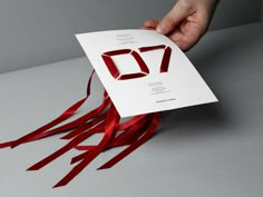 a person holding up a card with the number seventy on it and red streamers