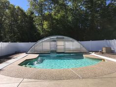 a swimming pool in the middle of a fenced off area with a glass enclosure over it