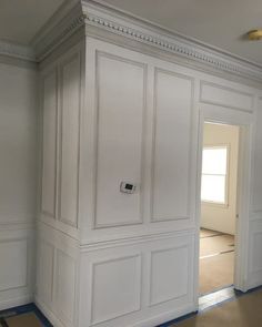 an empty room with white paneling and blue tape on the floor