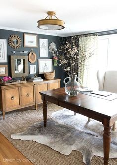 a living room filled with lots of furniture and pictures on the wall next to a window