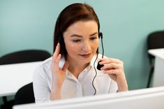 a woman wearing headphones while using a computer