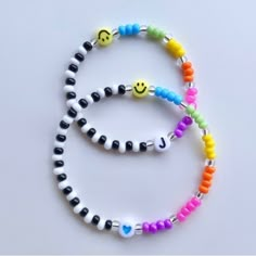 two bracelets with smiley face beads and hearts on each strander, one is multicolored