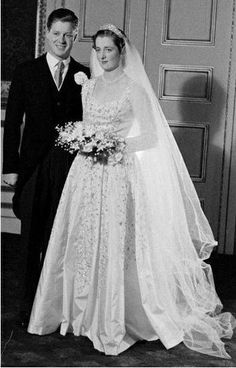 a bride and groom posing for a photo in front of a door at their wedding