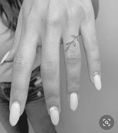 a woman's hand with a small tattoo on it