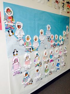 a bulletin board with cutouts of children's clothes and penguins on it in an office cubicle