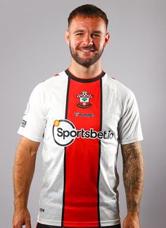 a man wearing a red and white soccer jersey