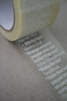 a roll of clear adhesive tape on top of a white tablecloth with words printed on it