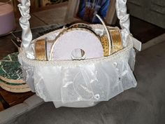 a white basket with gold trimmings on the bottom and two rings in it