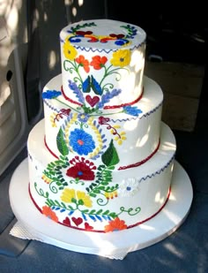 a three tiered cake sitting on top of a white plate next to a window