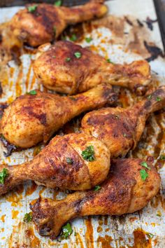 some chicken legs are sitting on a baking sheet