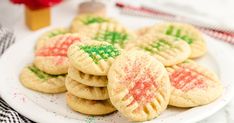 a white plate topped with cookies covered in sprinkles on top of a table