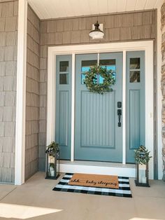 a blue front door with a welcome mat