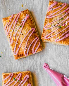 three square pastries with pink icing and sprinkles next to each other