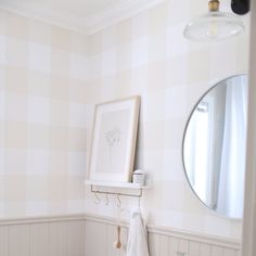 a white sink sitting under a bathroom mirror next to a wall mounted art print on the wall