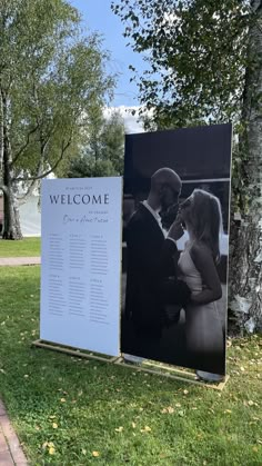 a welcome sign for a newly married couple in front of a large poster on the grass