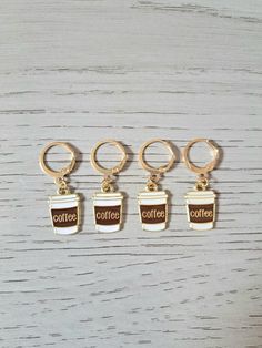 four coffee charms sitting on top of a wooden table