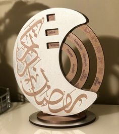 a white clock with arabic writing on it