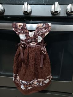 a brown apron hanging from the handle of an oven