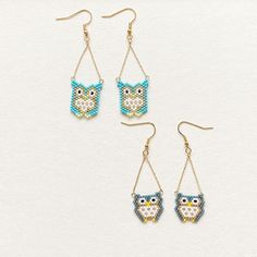 three pairs of beaded owl earrings with dangling hooks on a white surface, one is blue and the other is yellow