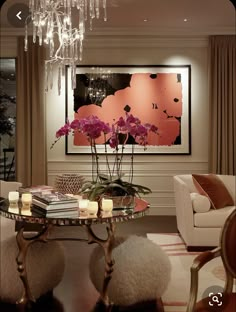 a living room filled with furniture and a chandelier above a glass top table