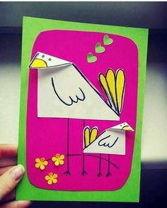 someone holding up a card with two birds on it