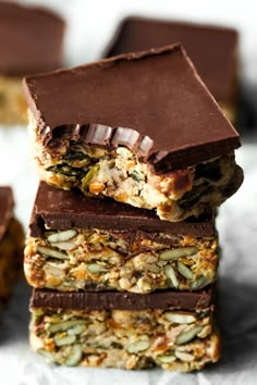 chocolate bars stacked on top of each other with nuts and seeds in the bottom half