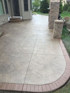 a concrete patio with brick pillars and steps