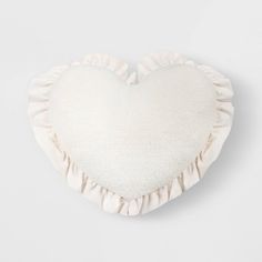 a white heart shaped pillow with ruffled edges