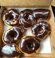 a box filled with lots of chocolate covered doughnuts