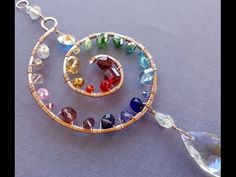 a multicolored glass beaded necklace on a silver chain with an open tear