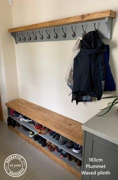 a coat rack with shoes hanging from it's sides next to a wall mounted shoe rack