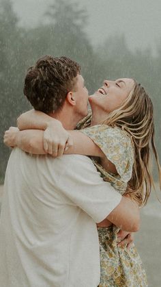 two people hugging each other in the rain