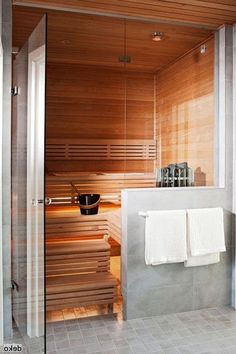 a bathroom with a sauna in the middle and towels hanging on the wall next to it