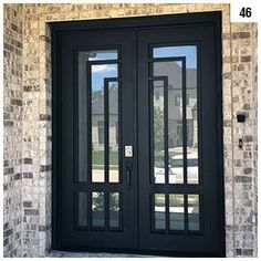 a black double door with sidelights and glass on the front of a brick building