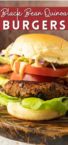 a burger with lettuce, tomato and cheese on it sitting on a wooden board