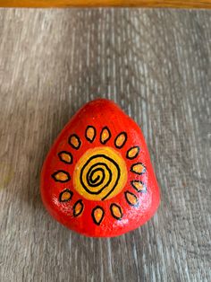 a painted rock sitting on top of a wooden table