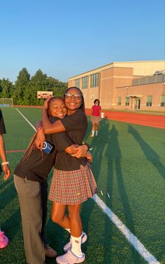 two women hugging each other on a field