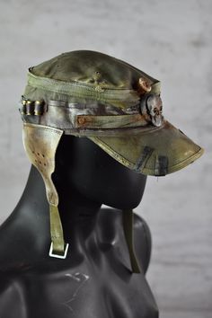 Postapoc Cap - Military Style Cap - Wasteland LARP Headpiece - Army Green Cap - LARP Accessories - Post Apocalyptic Hat - Handmade Headwear A unique post-apocalyptic styled cap. An olive green base, decorated with leather straps and stylish ear flaps. It's a unique costume piece that will add a spark of life to any military-style outfit! Finished with professional paintwork for a distressed effect, it has a very lifelike feel of a worn down headpiece. It's a one size product. More apocalyptic clothing: https://etsy.me/3Z2OHJ5 More accessories: https://etsy.me/2jskDVG MY ETSY SHOP: https://www.etsy.com/shop/WastedCouture Wear if you dare! --------------------------------------------------------------------- Wasted - Wasted Couture - WastedCouture Alternative Style Adjustable Cap, Adjustable Alternative Style Cap, Military Style Outfits, Larp Accessories, Apocalypse Clothing, Apocalyptic Clothing, Army Hat, Apocalyptic Fashion, Green Cap