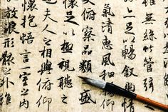 an ink pen sitting on top of a piece of paper with chinese characters written in cursive writing