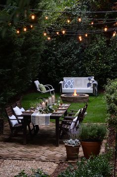 an outdoor dining area is lit up with string lights