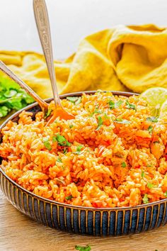 a bowl full of mexican rice and garnished with cilantro on the side