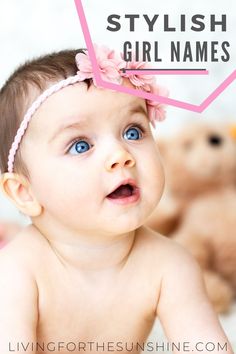 a baby with blue eyes wearing a pink headband and looking up at the camera