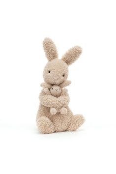 a stuffed rabbit sitting on top of a white floor next to a small teddy bear