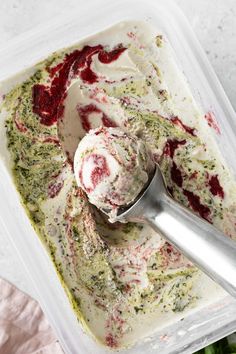 a scoop of ice cream in a plastic container with red and green sprinkles