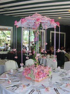 the table is set with pink flowers and umbrellas for an elegant wedding breakfasteon