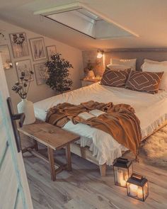 a bed sitting in the middle of a bedroom next to a wooden table with two lamps on it