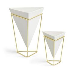 two white vases with gold trim on each side and one has a triangular design